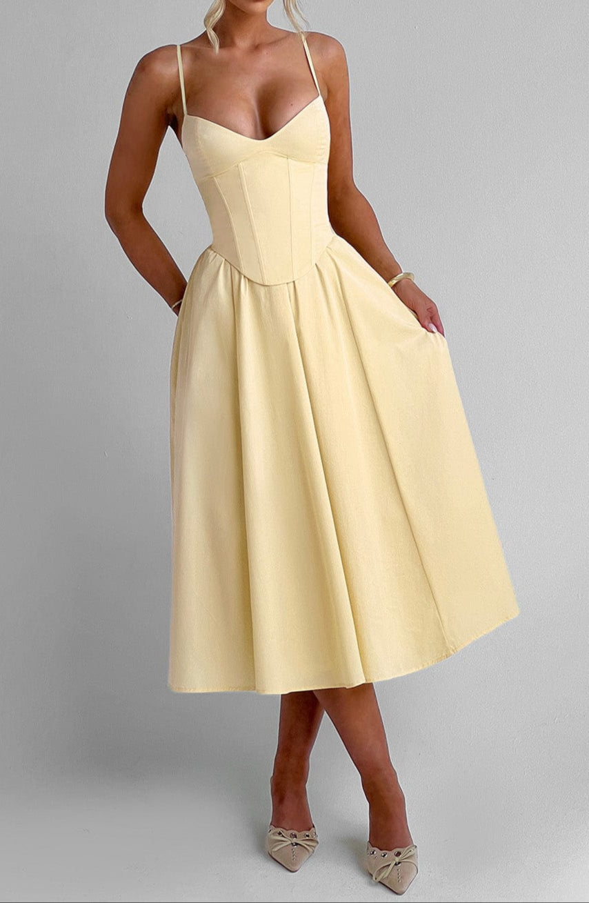 Gabrielle – Robe midi jaune coupe trapèze, bustier corseté structuré, décolleté cœur et poches latérales femme